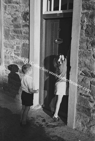 CHILDREN AT DOOR OF HOUSE